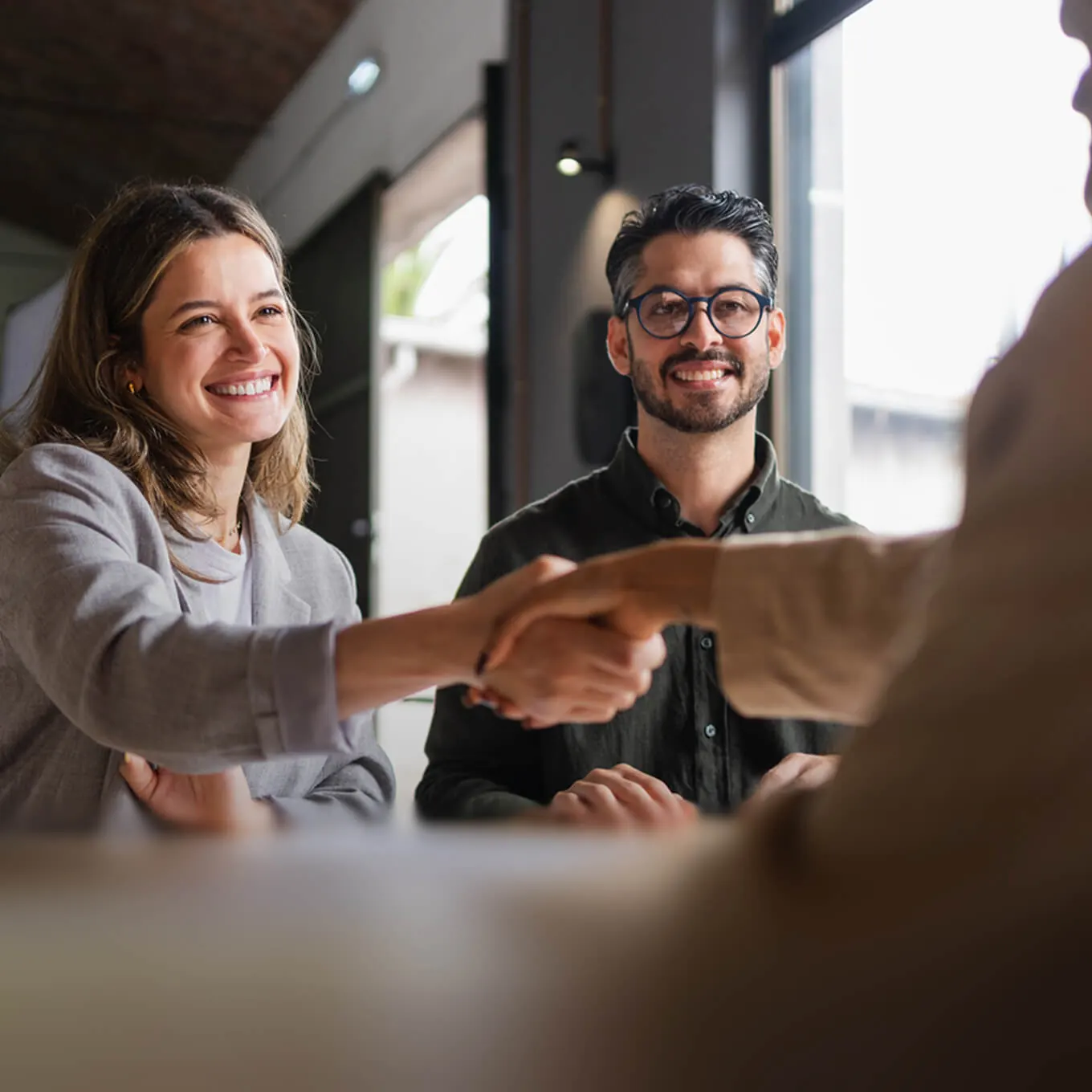 Colleagues greeting each other in a bright office